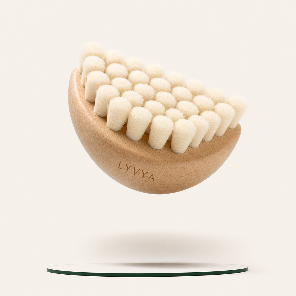 Brosse visage Lyvya demi-lune en bois clair aux poils ultra-doux, sur fond crème